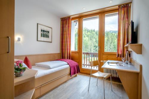 Un pat sau paturi într-o cameră la Berghotel Sudelfeld