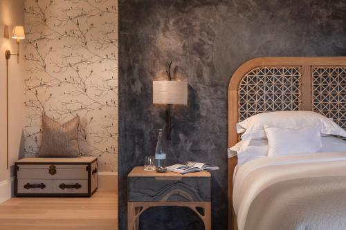 a bedroom with a bed and a side table with a lamp at Leeu Estates in Franschhoek