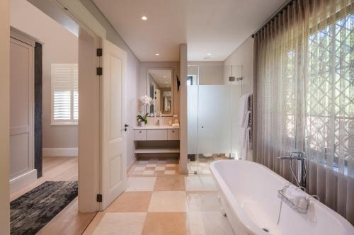 un ampio bagno con vasca e lavandino di Leeu Estates a Franschhoek