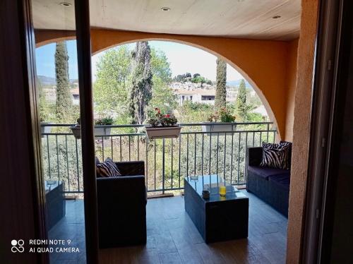 Cette chambre dispose d'un balcon avec deux canapés et une table. dans l'établissement Un nid d'amour en Provence à deux pas de la mer, à Cogolin