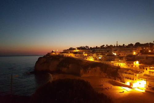 a group of buildings on a beach at night at ML Central Vila Apartment in Carvoeiro