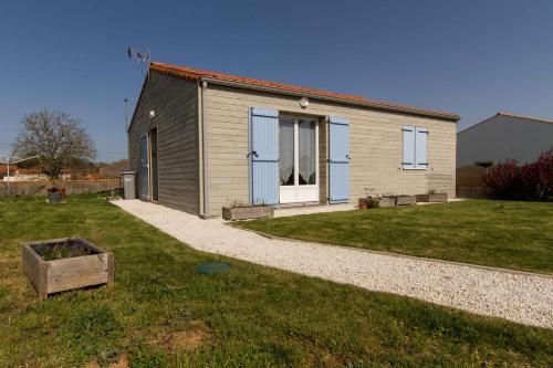 a small house in a yard with a grass field at le chalet vendéen in Saint-Hilaire-la-Forêt