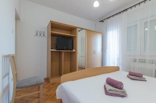 a bedroom with a bed and a tv and a chair at Apartments Spirit of the Sea in Tkon