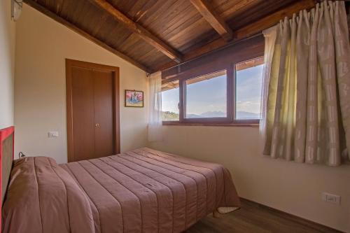 a bedroom with a bed and a window at Agripodere Il Falco in Pontremoli