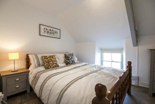 um quarto com uma cama e um candeeiro sobre uma mesa em Ashgrove Farm - 1 Bedroom Apartment - Llawhaden - Narberth em Narberth
