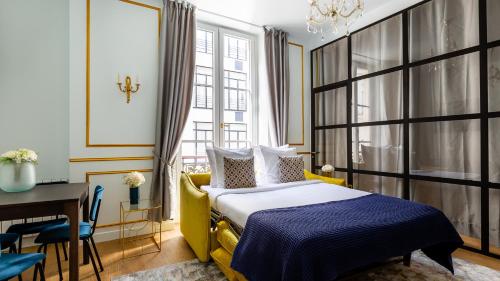 パリにあるLuxury 2 Bedroom 2 Bathroom Apartment - Louvreのベッドルーム(黄色のベッド1台、テーブル、椅子付)