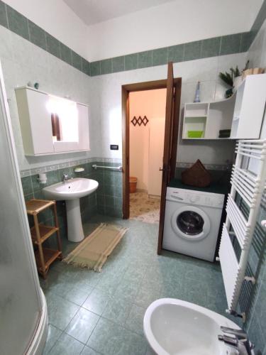 a bathroom with a sink and a washing machine at I colori di Otranto by CASASI Vacanze Otranto in Otranto