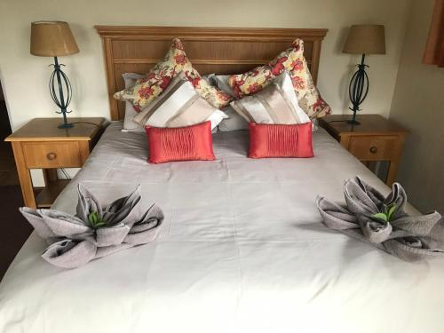 a bed with red and white pillows on it at Fairways Holiday Accommodation in Drakensberg Garden