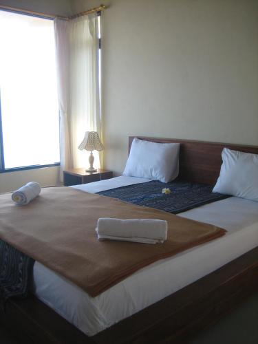 a bedroom with a large bed with a tray on it at Lucky Paradise Bungalows on The Beach in Amed