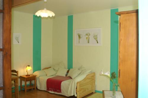 a bedroom with a bed with green and white stripes at Gites de la Filaterie in Cormatin