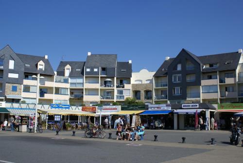 un groupe de personnes assises dans une rue devant les bâtiments dans l'établissement REF 145 Studio pour trois personnes vue Port Crouesty, à Arzon