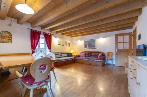 a living room with a table and chairs and a couch at Appartamento Vernelia Val di Fassa Sella Ronda in Campitello di Fassa