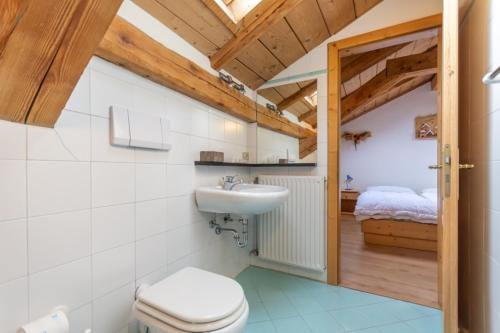 bagno con servizi igienici, lavandino e letto di Appartamento Vernelia by AMA Val di Fassa a Campitello di Fassa