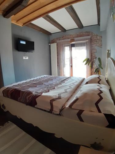 Cama grande en habitación con ventana en Apartament Mario en Sibiu