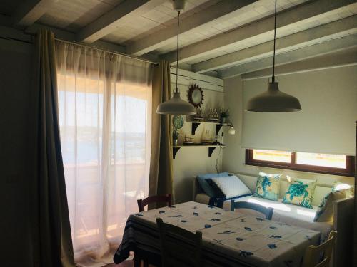 a room with a table and a bed and a window at Fronte mare Porto Vecchio in Lampedusa