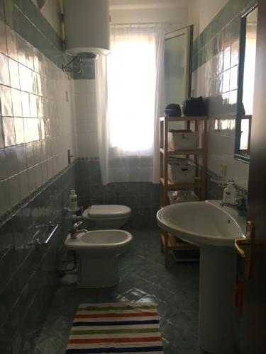 a bathroom with two sinks and a toilet and a window at Fronte mare Porto Vecchio in Lampedusa