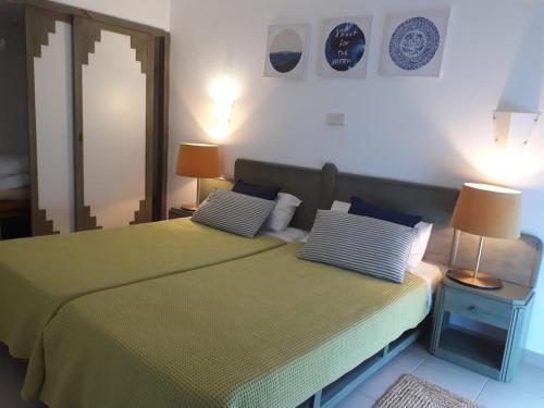 - une chambre avec un lit vert et 2 lampes dans l'établissement Clube praia da rocha III, à Portimão