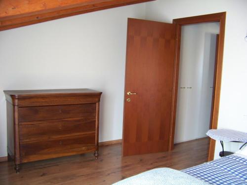 una camera da letto con cassettiera e porta in legno di Una mansarda luminosissima nel cuore di Stradella a Stradella