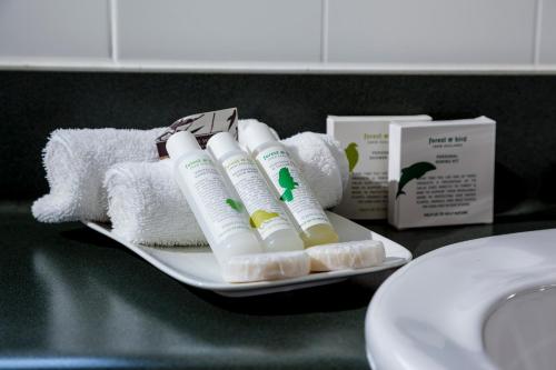 a tray with toiletries and towels on a bathroom counter at Fairley Motor Lodge in Napier