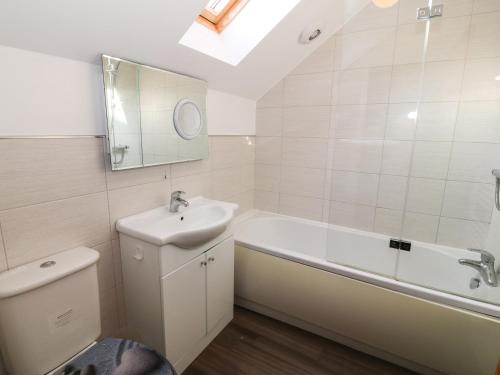 a bathroom with a sink and a tub and a toilet at Tan Bryn 1 in Aberdaron