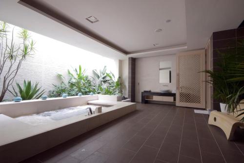 a large bathroom with a large tub and plants at Harport Motel in Niaosong