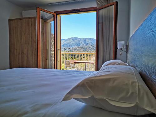 a bedroom with a bed and a large window at Ustaria in Peri