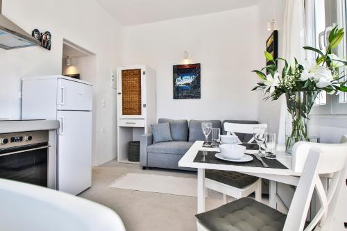 a kitchen and living room with a table and a couch at Lilly's Sunset Suite in Mikonos