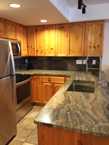 a kitchen with wooden cabinets and a granite counter top at Valhalla Vacations at Whistler in Whistler