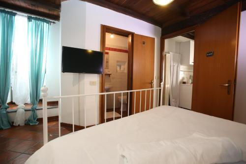 a bedroom with a bed and a flat screen tv at relax nel borgo L'ARCHETTO in Formello