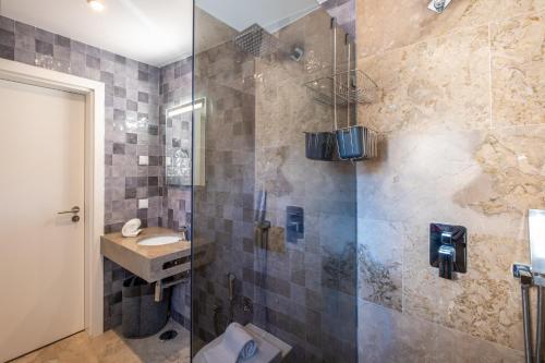 a bathroom with a glass shower with a sink at BELO HORIZONTE in Porches