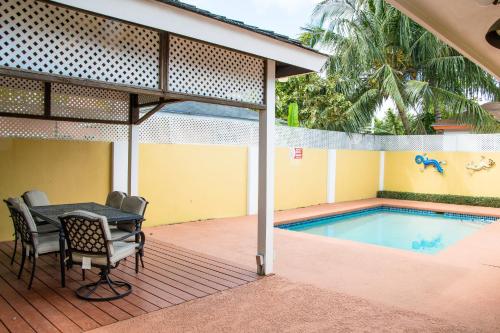 a patio with a table and chairs next to a swimming pool at Brownstone Guesthouses Seabeach in Nassau