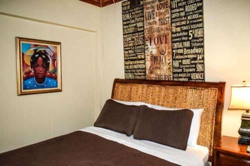 a bedroom with a bed with a picture on the wall at Brownstone Guesthouses Seabeach in Nassau