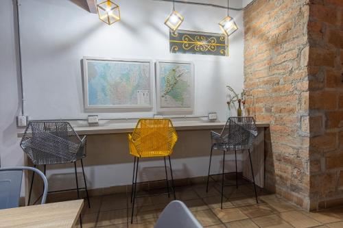 a dining room with three chairs and a table at Botánica Casa Hotel in Medellín