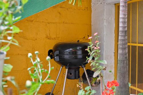 a yellow wall with a black pot on a wall at Botánica Casa Hotel in Medellín