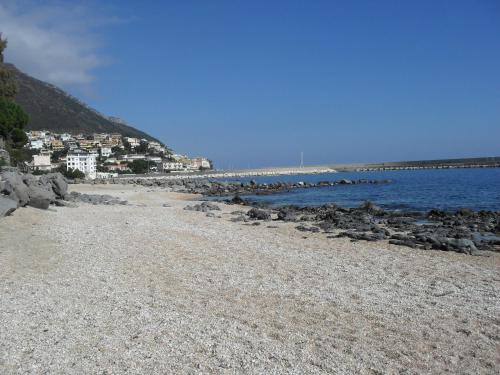 a rocky beach with a town in the background at B&B Fradama' Holiday in Dorgali