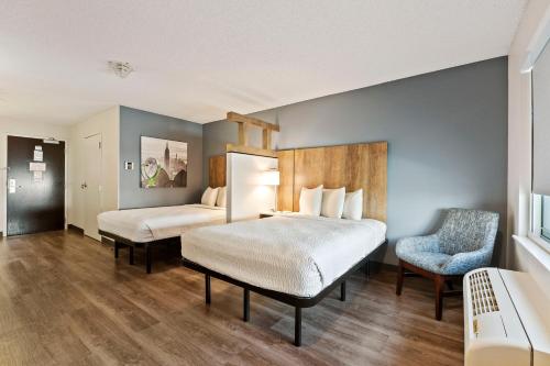 a hotel room with two beds and a chair at Extended Stay America Premier Suites - Miami - Airport - Doral - 25th Street in Miami