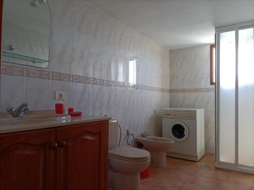 een badkamer met een toilet en een wasmachine bij El Somadero B in Fuencaliente de la Palma