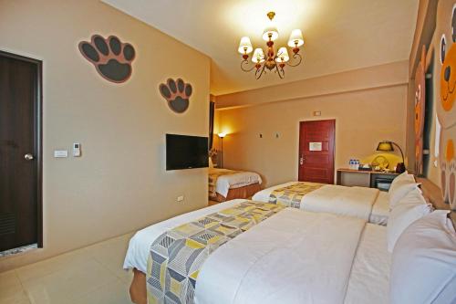 a bedroom with two beds with raised paws on the wall at Fun Trip - Little Castle & Oscar B&B in Taitung City