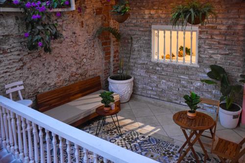 a patio with a bench and potted plants and a window at Casa Zahri Boutique Hostel in Cartagena de Indias