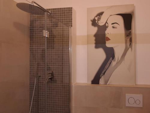 a bathroom with a shower with a picture of a woman at Foscolo 27 a 100 m dal mare in Viareggio
