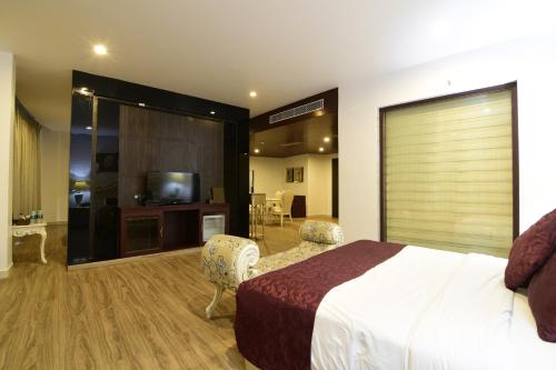 a hotel room with a bed and a television at Park Regis Goa in Arpora