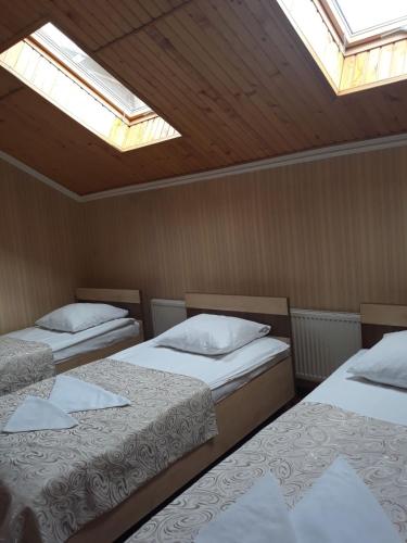 two beds in a room with two skylights at versal in Ternopilʼ