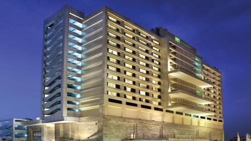 a tall white building with lights on at Holiday Inn New Delhi Mayur Vihar Noida, an IHG Hotel in New Delhi