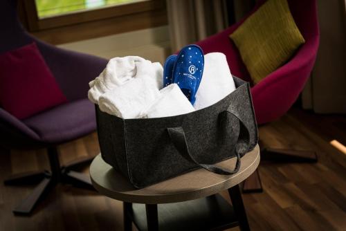 a basket of towels and shoes sitting on a table at Hotel Allegra in Pontresina