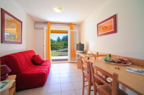 een woonkamer met een rode bank en een tafel bij Résidence Côté Sud Peypin in Peypin