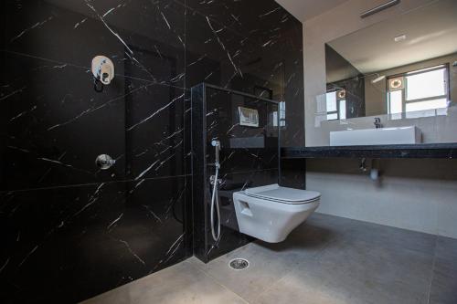 a black bathroom with a toilet and a sink at HOTEL VINTAGE CASTLE in Coimbatore