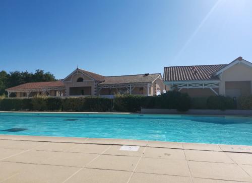 una piscina azul frente a una casa en Résidence le cordouan, en Soulac-sur-Mer