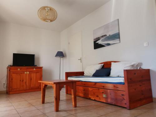 1 dormitorio con cama, mesa y TV en Résidence le cordouan, en Soulac-sur-Mer