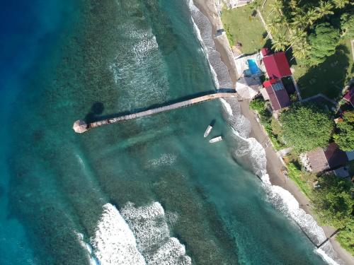 an aerial view of a beach with boats in the water at Sanctum Una Una Eco Dive Resort in Pulau Unauna