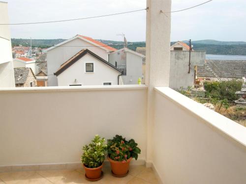 two potted plants sitting on the ledge of a balcony at Apartment Rosa in Primošten